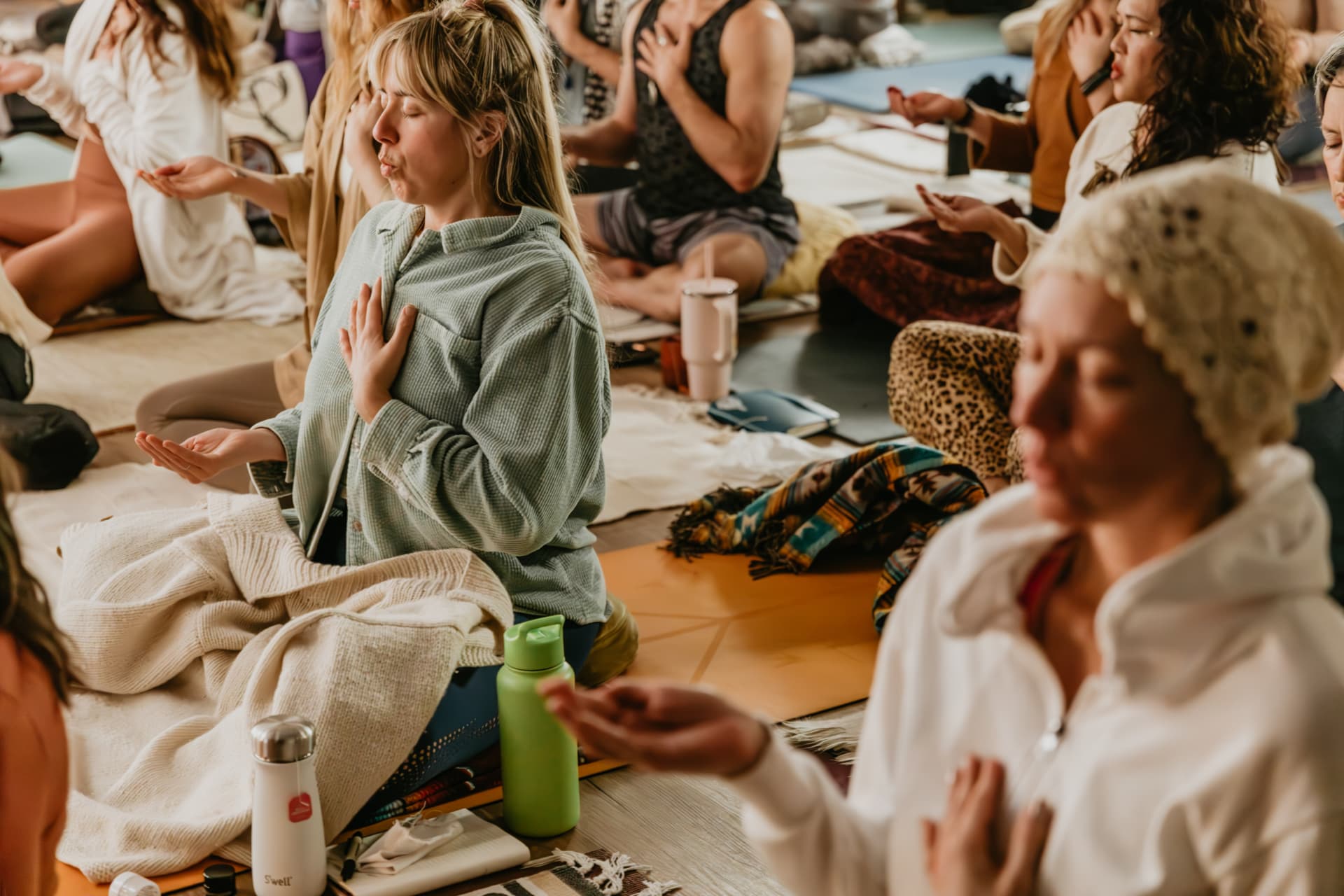 Circle of participants in seated breathwork with hands on hearts