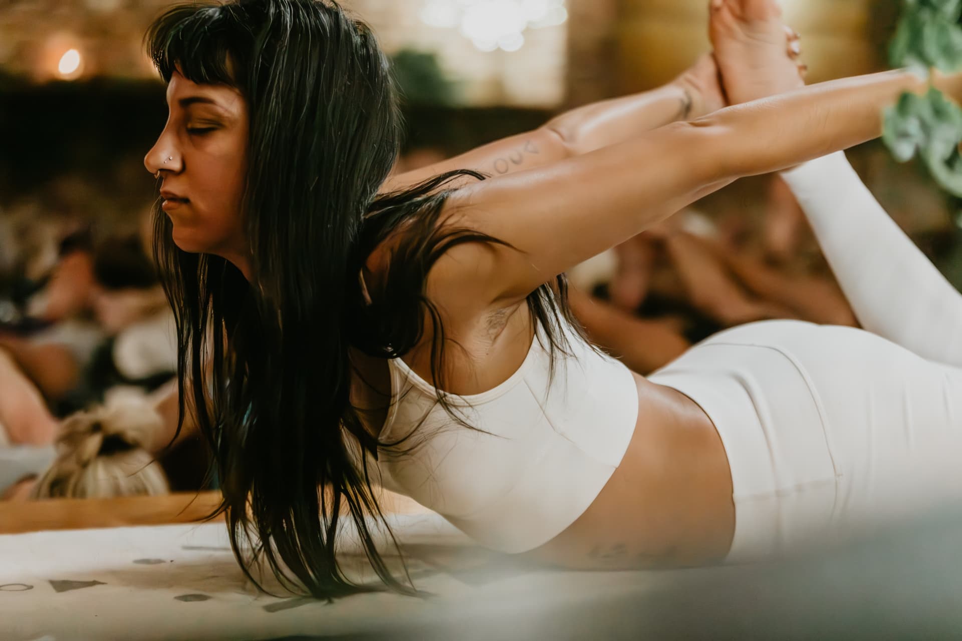 Participant in bow pose by candlelight