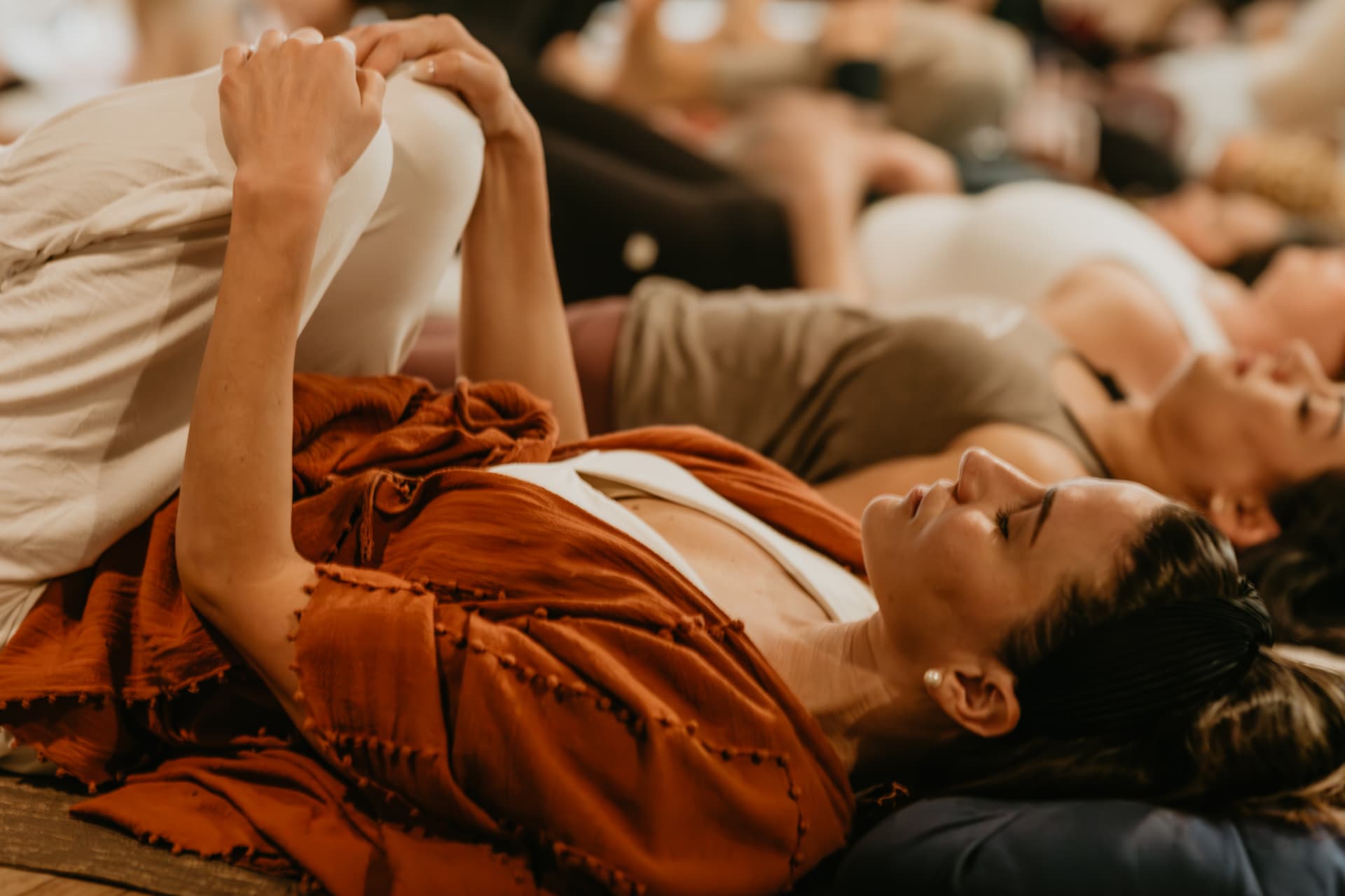 Participants resting in savasana wrapped in warm blankets