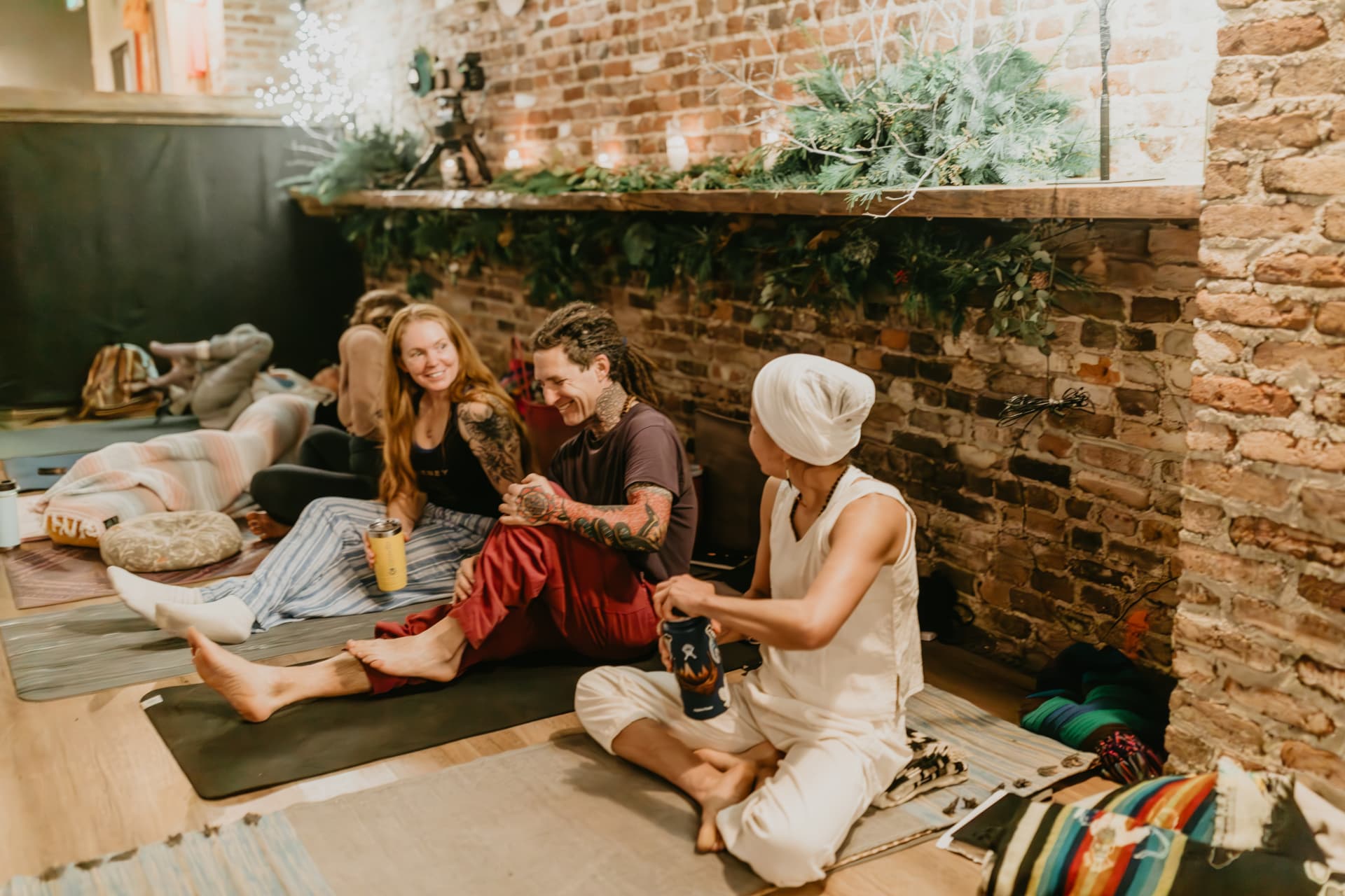 Participants sharing tea beside evergreen garlands