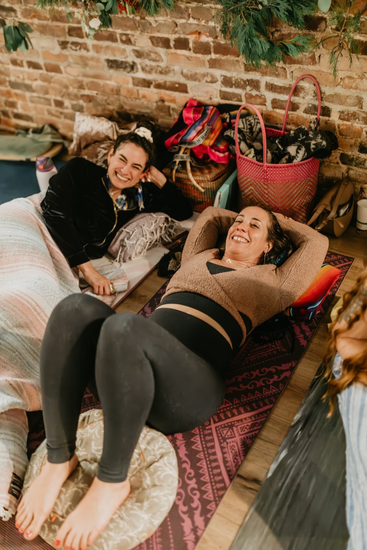 Two participants resting and laughing on their mats