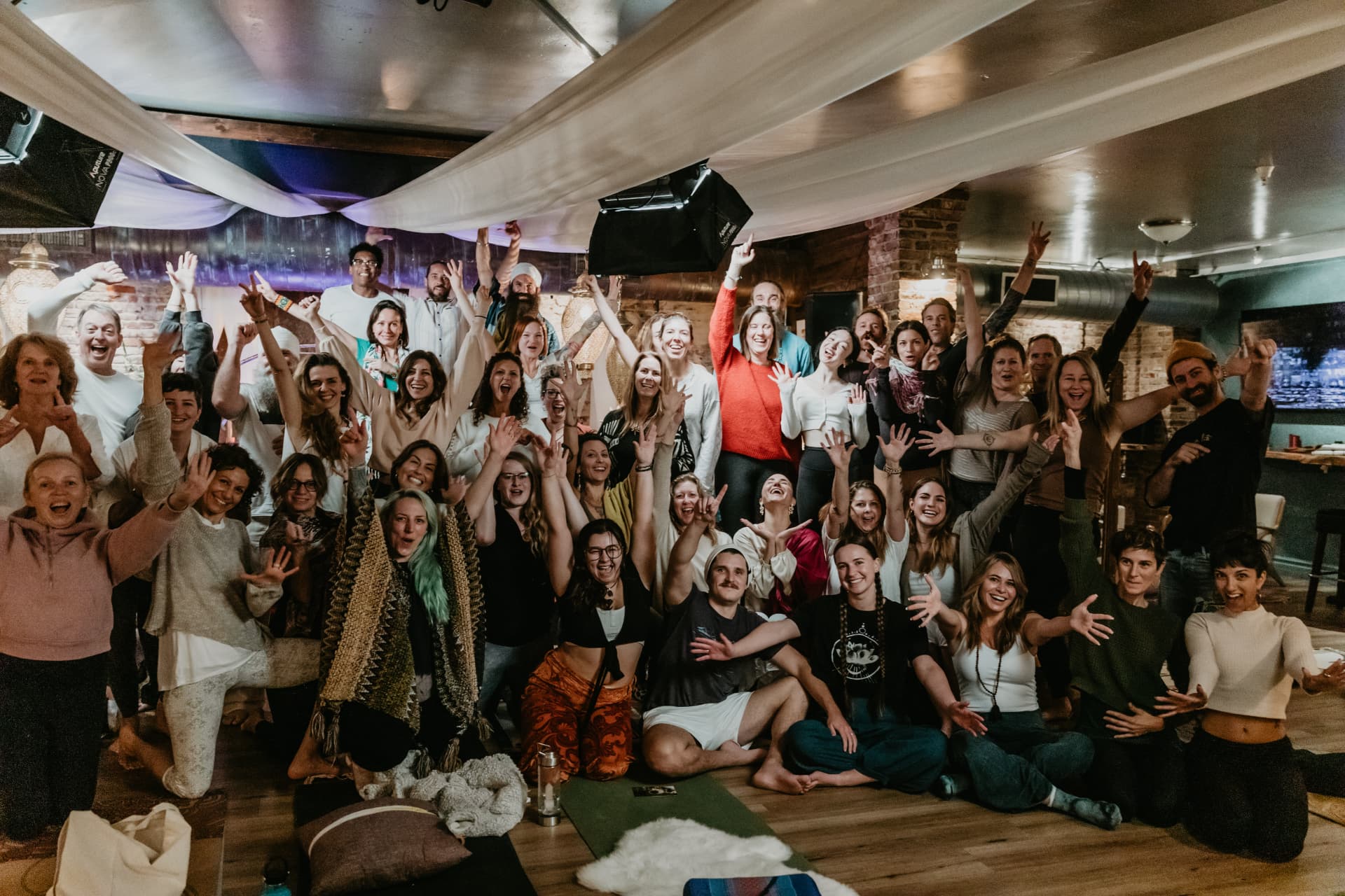 Large group of retreat participants celebrating together in the studio